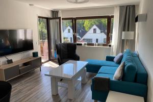 ベンドルフにあるAppartment mit Blick auf Schloss Saynの青いソファとテレビのあるリビングルーム