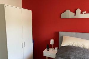ベンドルフにあるAppartment mit Blick auf Schloss Saynの赤い壁のベッドルーム(ベッド1台付)