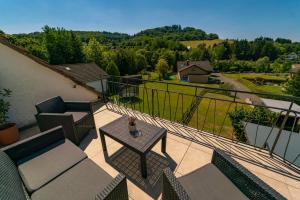 a patio with a table and chairs on a balcony at North Loop Rooms in Adenau