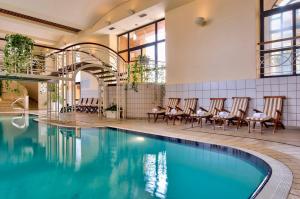 ein Pool in einem Hotel mit Stühlen um ihn herum in der Unterkunft Corinthia Hotel St. George’s Bay in St Julian's