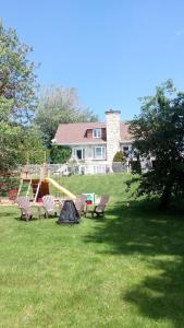 a group of chairs in a yard with a playground at Appartement Bellevue in Saint-Félicien