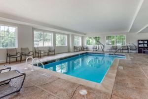 a pool in a room with chairs and a table at Comfort Suites in Clarksville