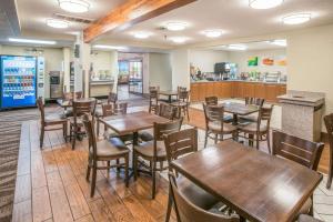 un restaurante con mesas y sillas de madera y una barra en Quality Inn Kanab National Park Area en Kanab