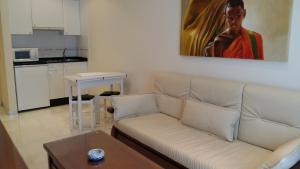 a living room with a couch and a painting on the wall at Apartamentos Maritimo Suites-Solo Adultos in O Grove