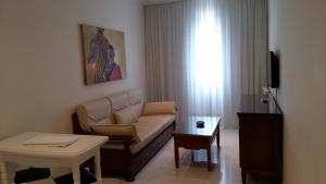 ein Wohnzimmer mit einem Sofa und einem Tisch in der Unterkunft Apartamentos Maritimo Suites-Solo Adultos in O Grove