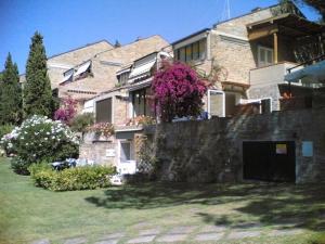 un gran edificio de ladrillo con flores en la pared en Appartamento su Residence, en Punta Ala