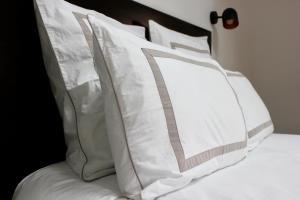 un montón de almohadas encima de una cama en Le Chemin du Village, en Croth