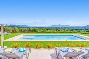 uma villa com uma piscina e espreguiçadeiras em Ca'n Gatulux em Pollença