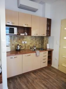a kitchen with a sink and a microwave at Embassy Studio Apartment Citypark in Budapest