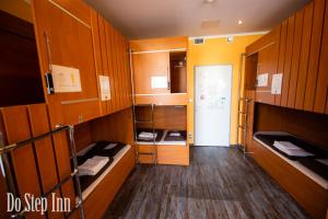 Zimmer mit mehreren Etagenbetten und einer Tür in der Unterkunft Do Step Inn Central - Self-Service-Hostel in Wien