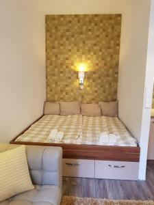 1 dormitorio pequeño con 1 cama y 1 sofá en Embassy Studio Apartment Citypark, en Budapest