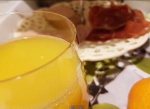 a glass of orange juice next to a plate of food at City Lodge Stay A while in Zwolle