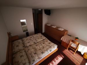 um quarto com uma cama e uma cadeira em Hotel Restaurant Aletsch em Mörel