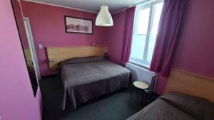 a small bedroom with a bed and a window at hotel Melissa in Péruwelz