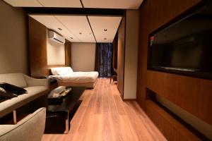 een hotelkamer met een bank en een flatscreen-tv bij Guests Inn in Riyad