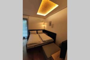 ein kleines Schlafzimmer mit einem Bett und einem gelben Licht in der Unterkunft Appartement Toni in Sand in Taufers