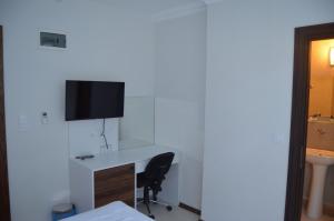 a room with a desk and a tv on a wall at Grand Antalya Hotel in Antalya