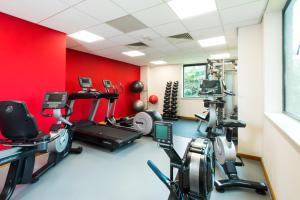 un gimnasio con máquinas de cardio y una pared roja en ibis Styles Birmingham NEC & Airport, en Bickenhill