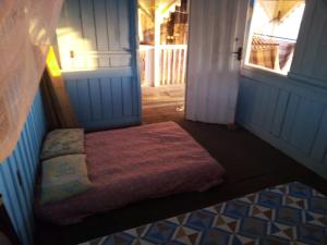 Dormitorio pequeño con cama en la puerta en HOSTEL MAIANDEUA, en Algodoal