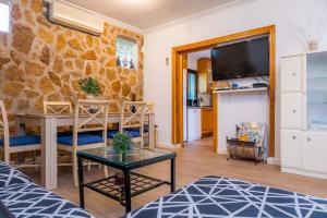 ein Wohnzimmer mit einem Tisch und einer Steinmauer in der Unterkunft Casa Paqui Alcudia in Port d'Alcúdia