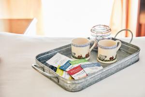 ein Tablett mit zwei Tassen und Packungen Tee in der Unterkunft The Bateman Arms at Shobdon in Shobdon
