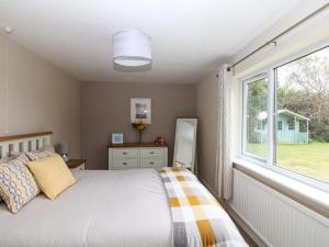a bedroom with a bed and a window at Trevore Farmhouse in Truro