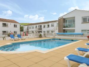 una piscina con sedie blu accanto a un edificio di 2 Europa Court a Newquay