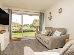 a living room with a couch and a large window at 2 Europa Court in Newquay