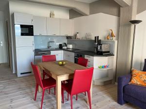a kitchen with a wooden table and red chairs at Speicher Residenz Barth E3 App 1 in Barth