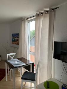 a living room with a table and a window at Mini-Ferien-Suite Hildesheim in Hildesheim