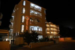 a tall building with a sign on it at night at Villa Verica in Baška Voda