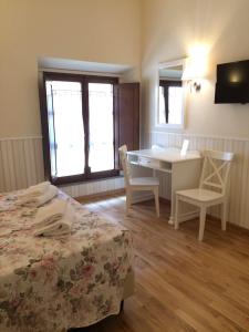 una camera con letto, tavolo e sedie di Relais Campanile Adelaide a Firenze