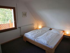1 dormitorio con 1 cama y una ventana con 2 lámparas en Ferienwohnungen Stegen, en Stegen