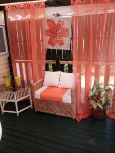 a porch with a wicker chair on a deck at Mobil-home 6 personnes in Mimizan
