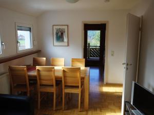 a dining room with a wooden table and chairs at Ferienwohnungen Stegen in Stegen +30 photos