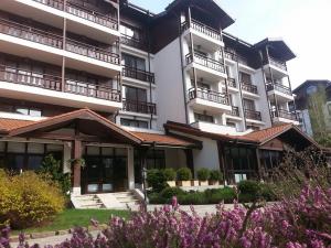 an exterior view of a building with purple flowers at Winslow Infinity Aparthotel in Bansko