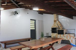 a living room with a wooden table and a fireplace at Recanto do Tião in Itapira