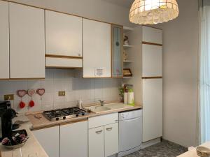 Una cocina con gabinetes blancos y un fregadero. en MAISON IVA & GIO' OLD STYLE, en Génova