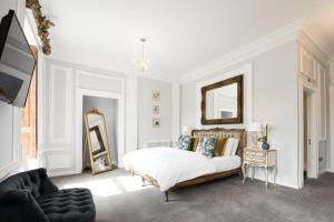 Habitación blanca con cama y espejo en Beamish Hall Country House Hotel, BW Premier Collection en Stanley