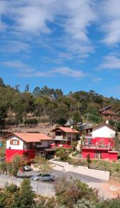 a group of houses with red and white at Pousada Nascer da Lua in Monte Verde