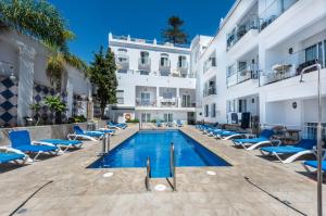 une image d'une piscine de l'hôtel avec des chaises bleues dans l'établissement Toboso Apar - Turis, à Nerja