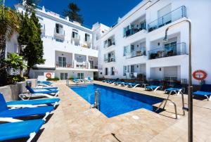 a hotel with a swimming pool in front of a building at Toboso Apar - Turis in Nerja