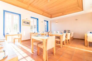 a dining room with tables and chairs and windows at HOTEL LOUSAL Grandola in Lousal
