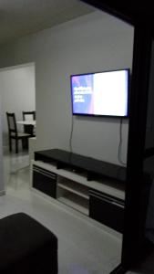 sala de estar con TV de pantalla plana en la pared en BEIRA MAR DE JATIÚCA, en Maceió