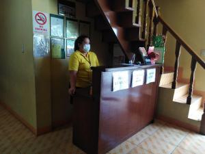 a woman wearing a mask standing at a counter at RedDoorz near SM Batangas City in Batangas City