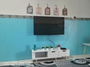 a living room with a tv on a blue wall at Zumara Homestay Jerantut Pahang in Jerantut