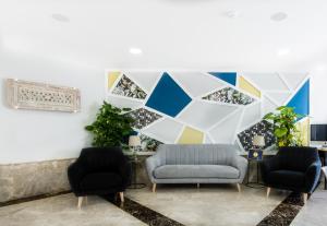 a living room with two chairs and a geometric wall at Toboso Apar - Turis in Nerja