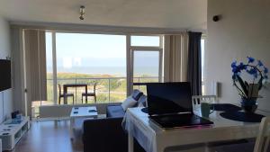 ein Wohnzimmer mit einem Tisch und einem Laptop darauf in der Unterkunft Blue Horizon in Bredene