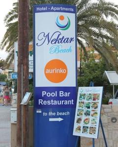 Nektar Beach Hotel في ستالوس: وجود علامة على مطعم بار المسبح في الشارع