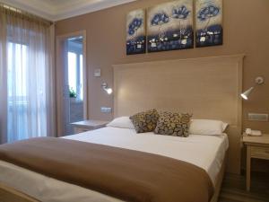 a bedroom with a large bed with two paintings on the wall at Casa Eli Roma B&B in Rome